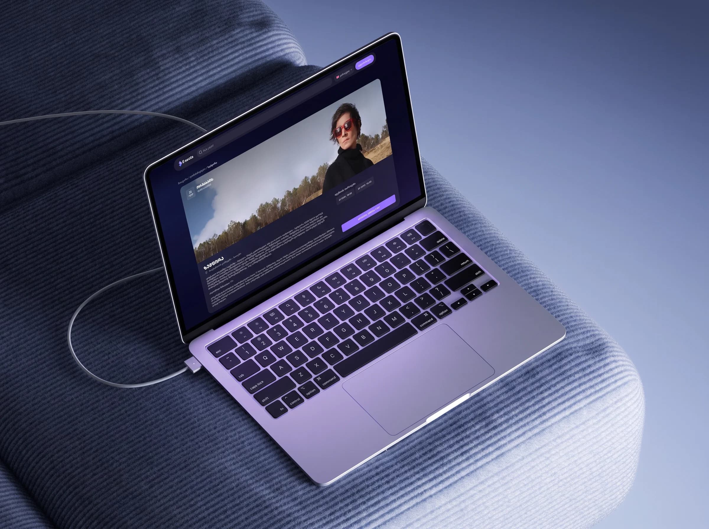 E-Seats event page on a MacBook sitting on a violet corduroy seat