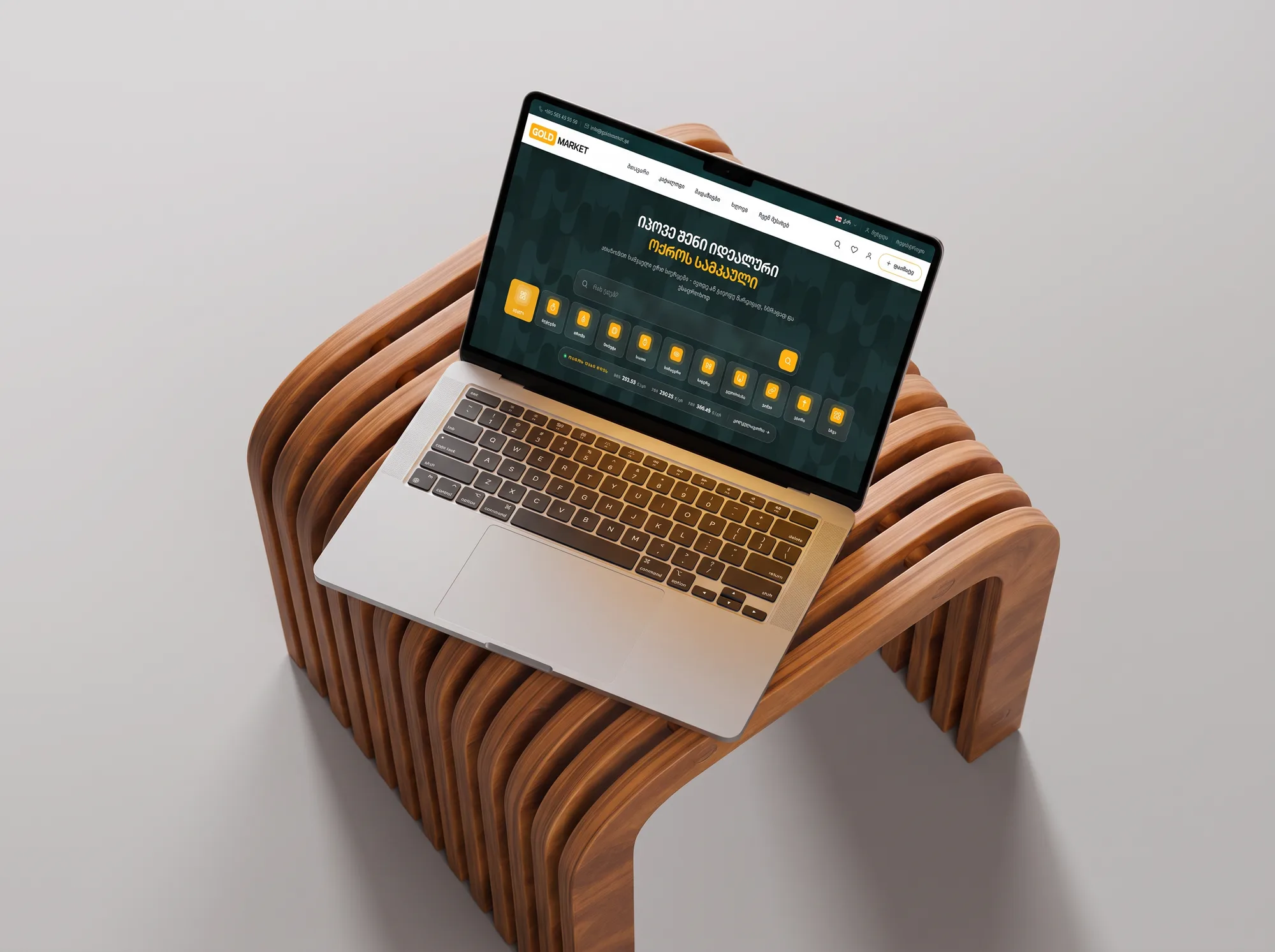goldmarket.ge on a MacBook tilted on the slatted bench