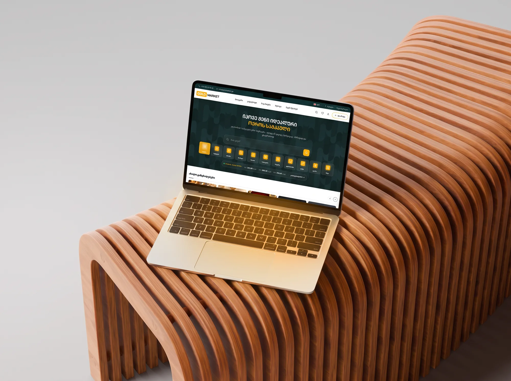goldmarket.ge on a MacBook on the slatted bench, from the right