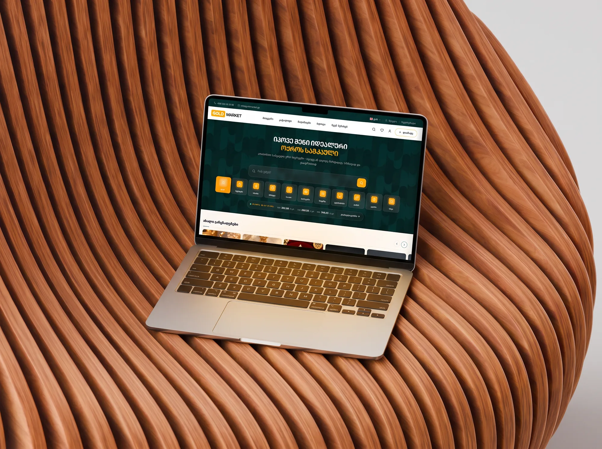 goldmarket.ge on a MacBook on the slatted bench, close